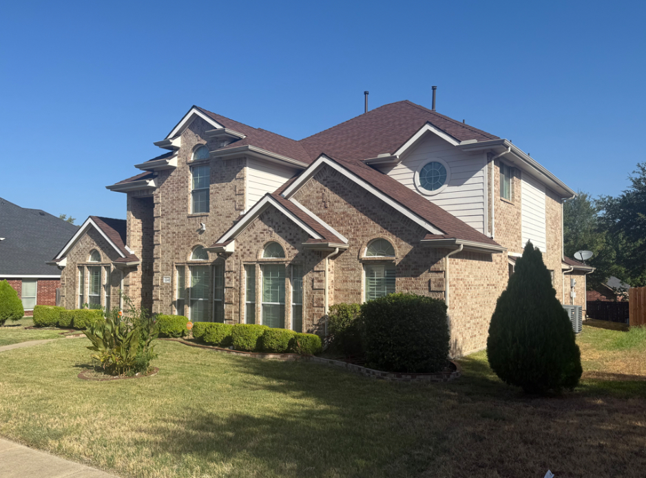 Two-story brick home during the day before permanent lighting is illuminated