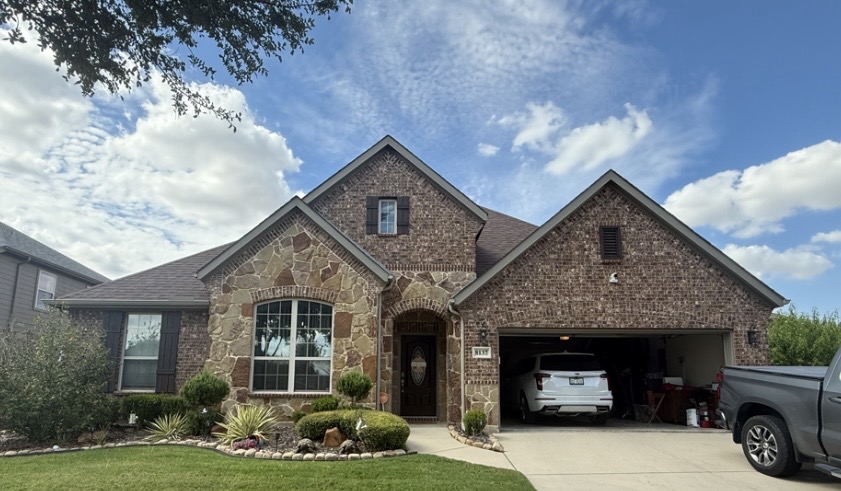 Brick-and-stone home with twin front gables during the day, lights off